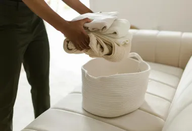 White linens being placed into a real laundry basket