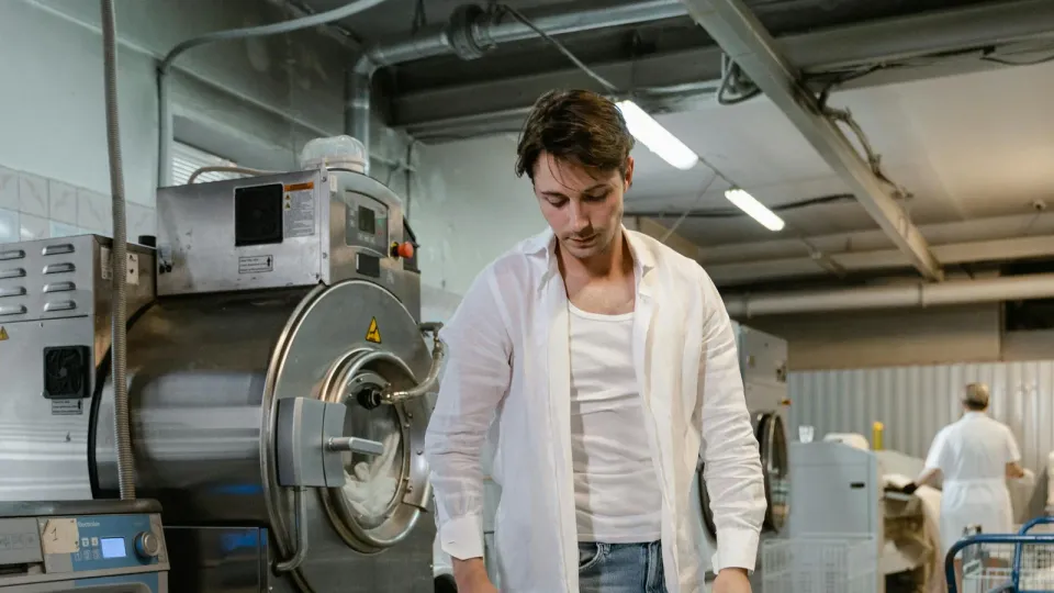 A real commercial laundry room with carts and front-load machines