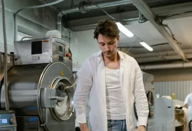 A real commercial laundry room with carts and front-load machines