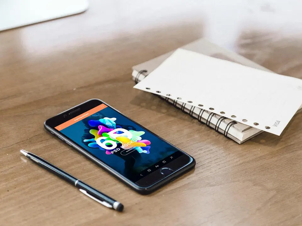 A smartphone, notepad, and pen ready for a terms question