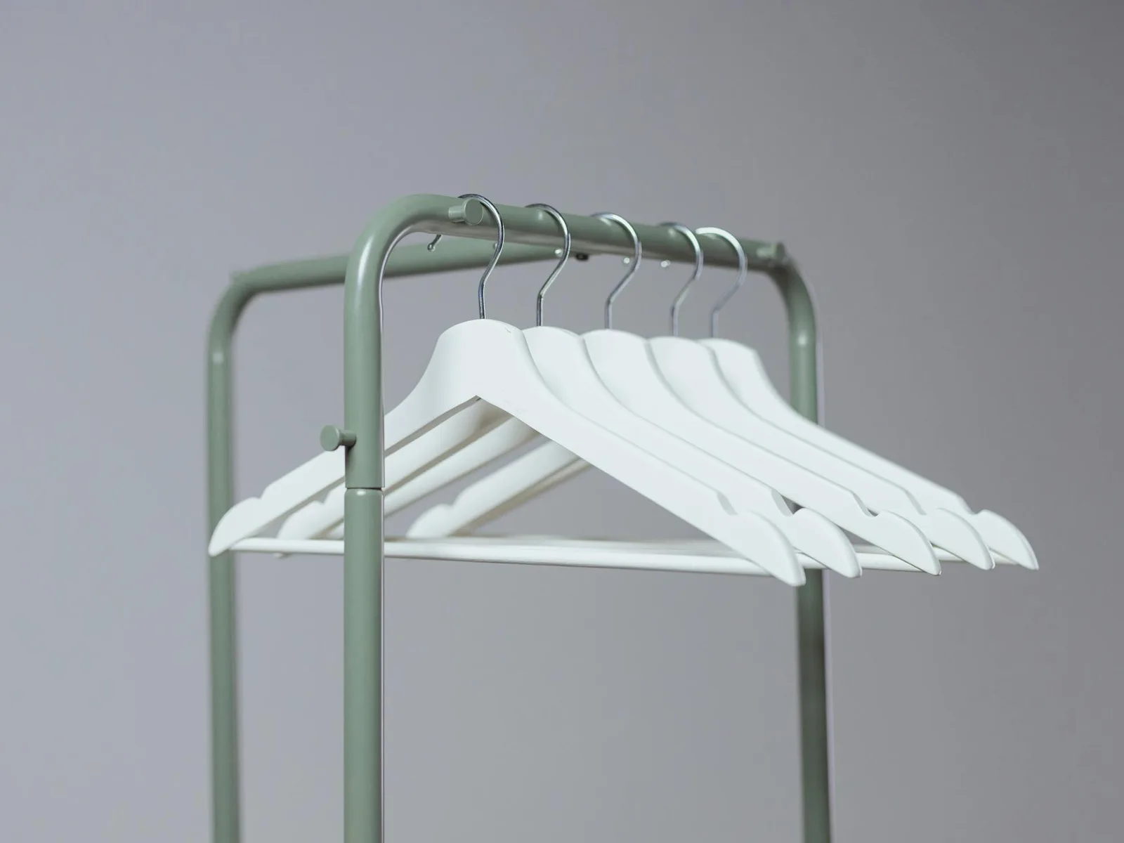 A row of empty clothes hangers on a garment rack