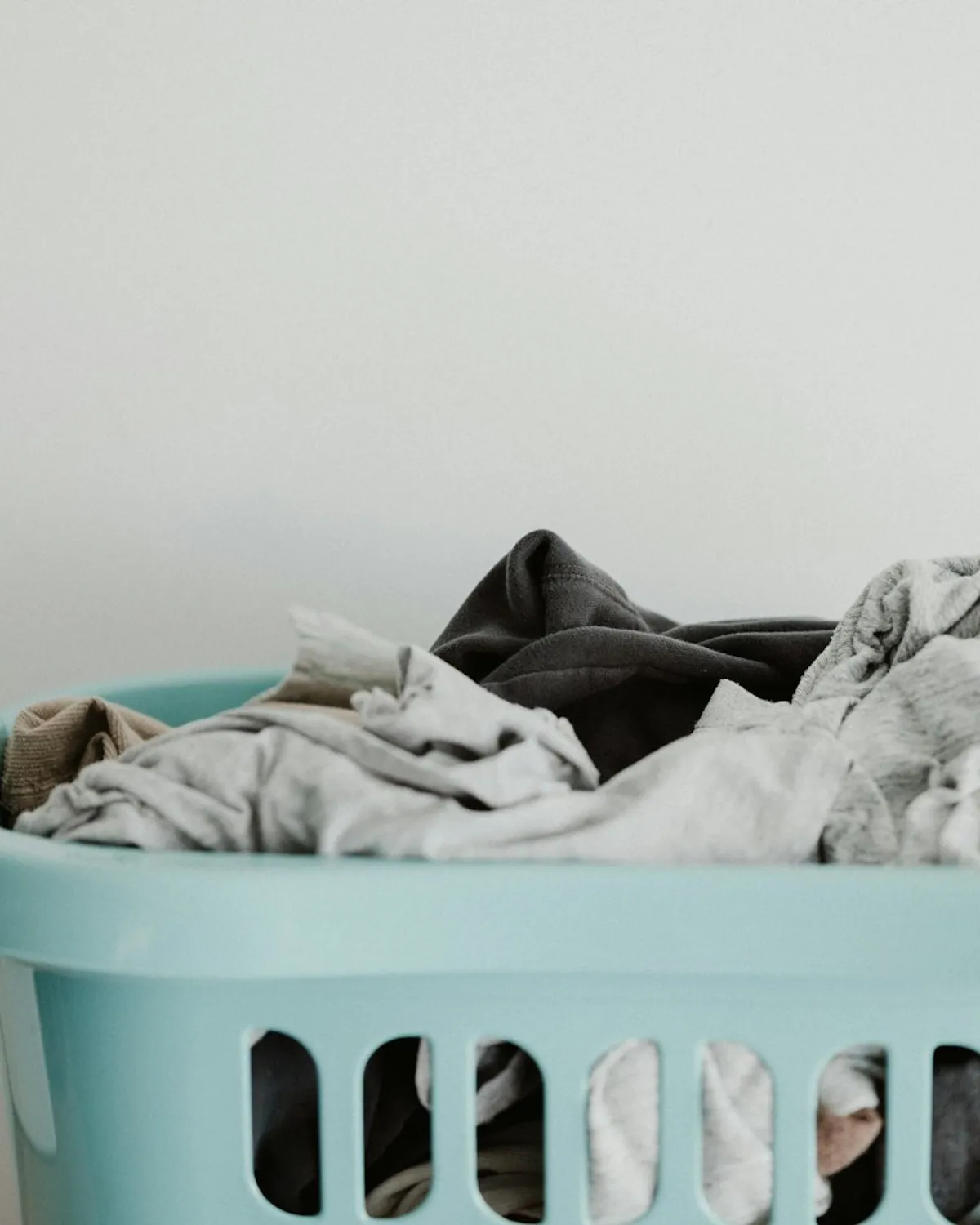 A sealed laundry bag waiting on a sunlit porch step.